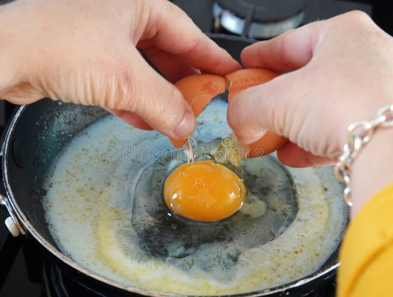 Single Cracked Egg Poured Onto a Pan in the Kitchen Stock Photo Image
