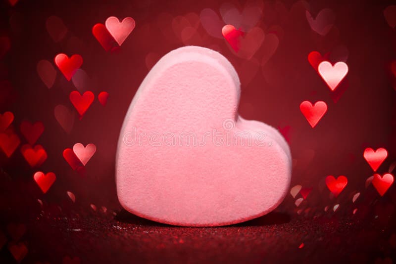 Single large blank candy heart for Valentines day surrounded with shiny hearts stock image