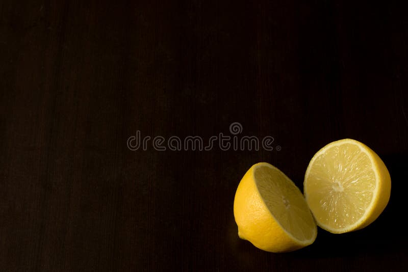 Single lemon sliced in half on dark background stock images