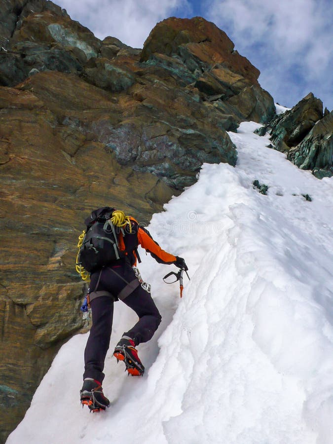 Single male mountaineer climbing a steep north face in Switzerland