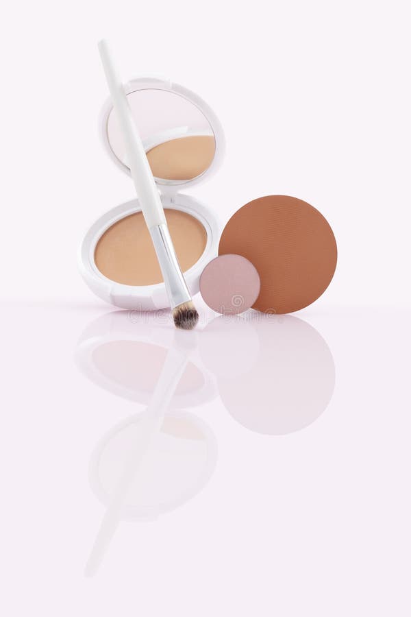 Opened compact powder, blusher with makeup Brush and refill pan on Glossy Surface stock photos