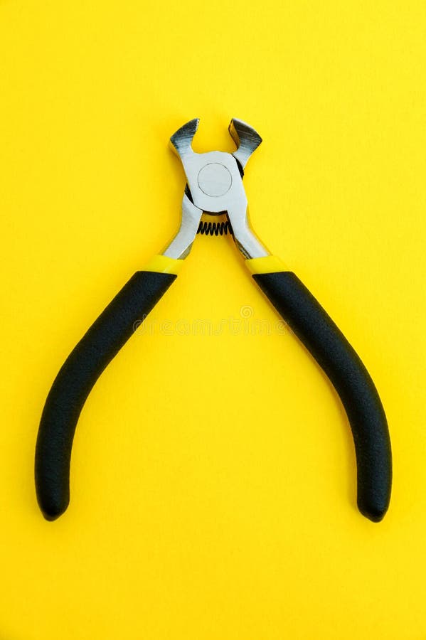 Single pliers tool with rubber handles for the master electrician on yellow background stock photography Single pliers tool with rubber handles for the master electrician on yellow background stock photography