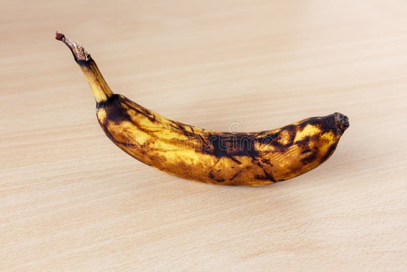 Black Spoiled Banana In Hand. A Hand Is Holding A Rotten Black Or Brown