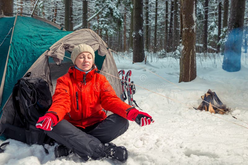 Single trekking in the winter forest, girl doing yoga