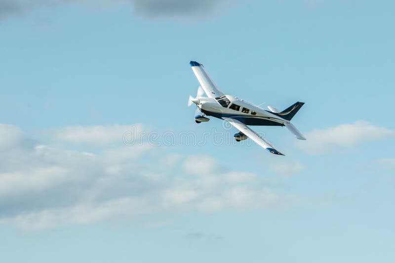 Single piston aircraft. Single-propeller aircraft flying over the blue sky at a small airport. Single piston aircraft. Single-propeller aircraft flying over the blue sky at a small airport