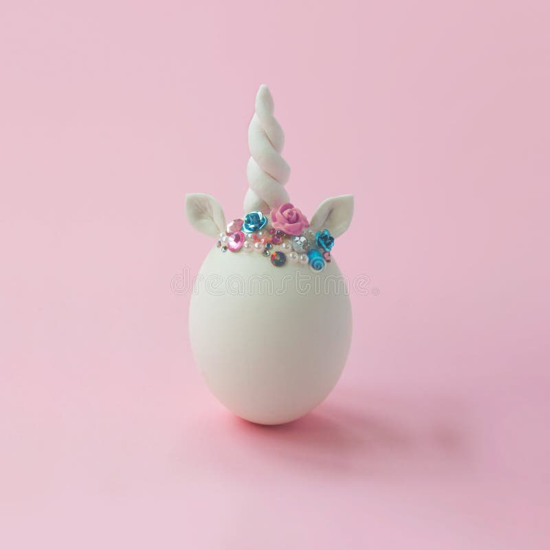 Single white egg, with unicorn decoration; Creative minimal Easter background stock photos