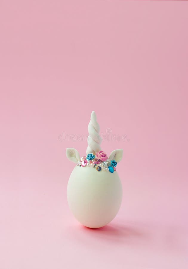 Single white egg, with unicorn decoration; Creative minimal Easter background with copy space stock photography