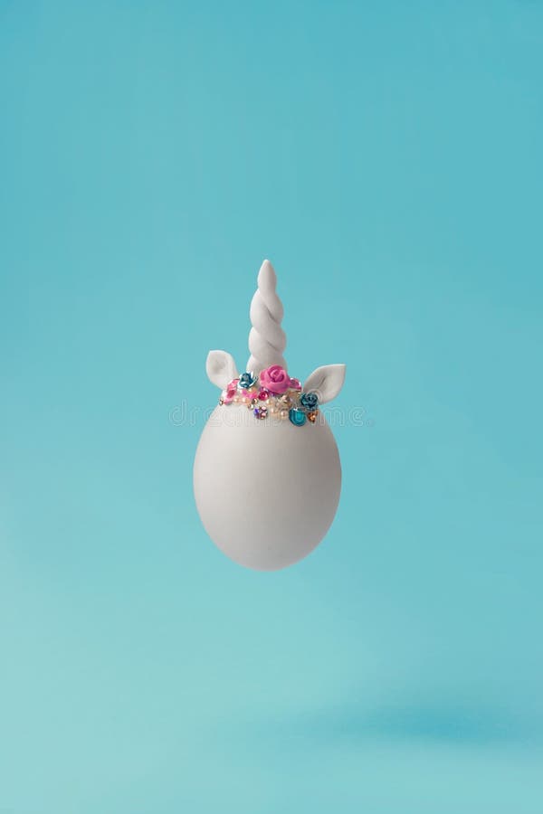 Single white egg, with unicorn decoration; Creative minimal Easter background royalty free stock photo