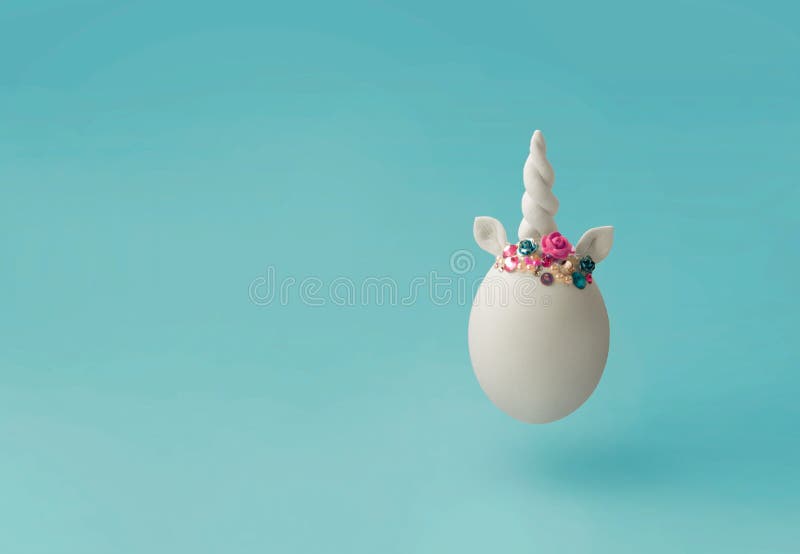 Single white egg, with unicorn decoration; Creative minimal Easter background royalty free stock images