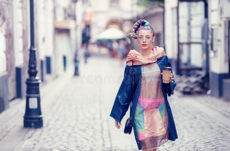 Single edgy girl with extravagant look on streets. Crazy appearance on boulevard. Avant-garde fashion concept stock images Single edgy girl with extravagant look on streets. Crazy appearance on boulevard. Avant-garde fashion concept stock images