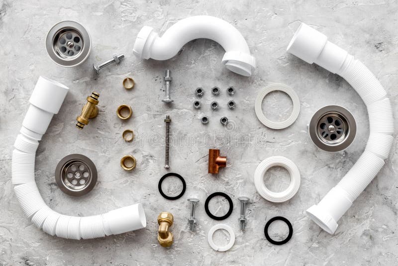 Sink Drain Parts and Plumbing Tools on Grey Stone Background Top View