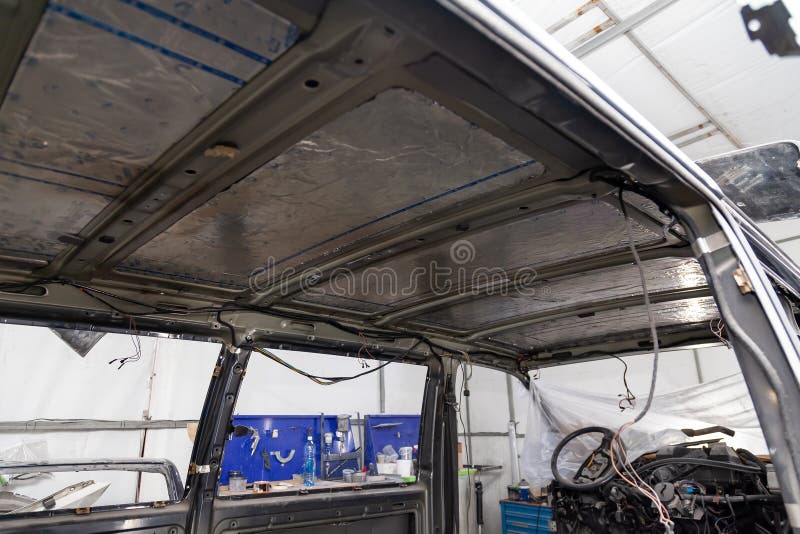 Sintonizzazione dell'automobile in un corpo del bus del furgone con tre strati dell'isolamento di rumore sul tetto del metallo Su immagine stock libera da diritti Sintonizzazione dell'automobile in un corpo del bus del furgone con tre strati dell'isolamento di rumore sul tetto del metallo Su immagine stock libera da diritti