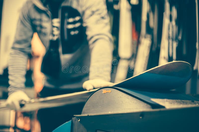 Sintonizzazione e reapairs dello snowboard Lavoratore del negozio di inverno che fa il rappresentante della base immagini stock libere da diritti Sintonizzazione e reapairs dello snowboard Lavoratore del negozio di inverno che fa il rappresentante della base immagini stock libere da diritti