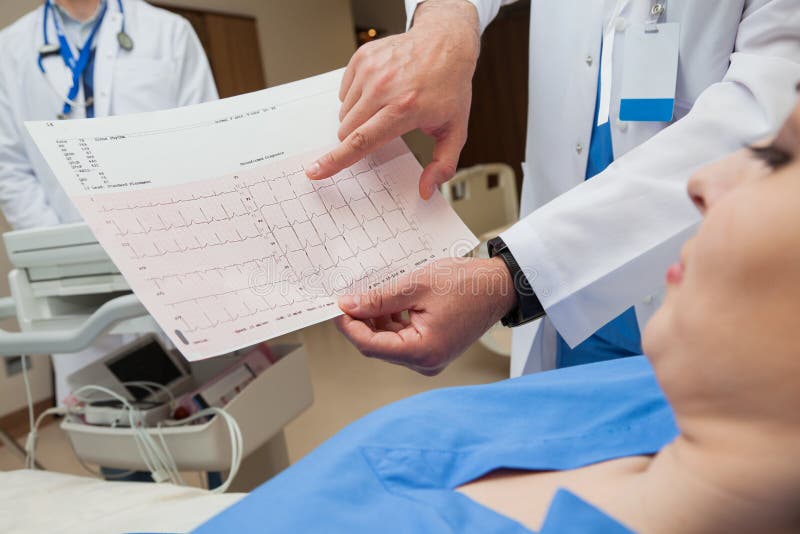 Close-up of a doctor, hands only, showing a normal sinus rhythm sheet to a young female patient. Close-up of a doctor, hands only, showing a normal sinus rhythm sheet to a young female patient.