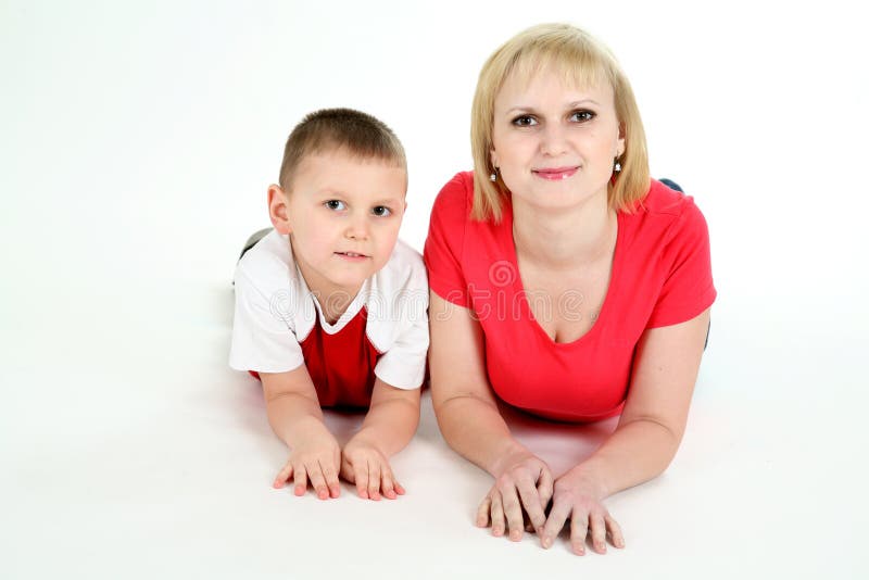 Sira de mãe e a mentira do filho em um assoalho. imagem de stock Sira de mãe e a mentira do filho em um assoalho. imagem de stock