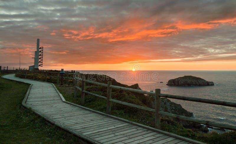 Sirena e passaggio pedonale di legno vicino al capo di Peñas del faro su una bella costa di tramonto delle Asturie, Spagna fotografie stock libere da diritti Sirena e passaggio pedonale di legno vicino al capo di Peñas del faro su una bella costa di tramonto delle Asturie, Spagna fotografie stock libere da diritti