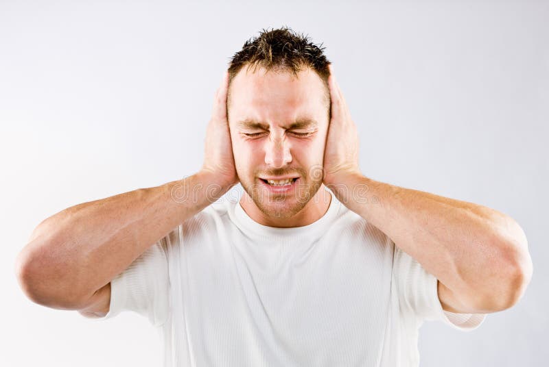 Man blocking out loud noises by holding his ears. Man blocking out loud noises by holding his ears.