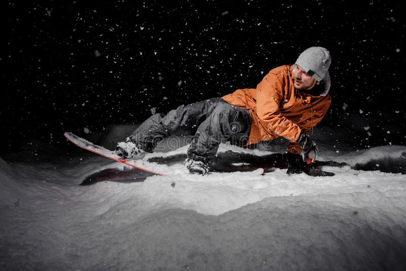 Sirva el montar a caballo en la snowboard en el centro turístico de montaña en la noche imagen de archivo libre de regalías Sirva el montar a caballo en la snowboard en el centro turístico de montaña en la noche imagen de archivo libre de regalías