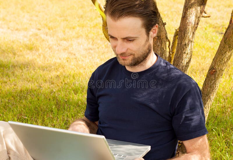 Sirva el trabajo en el ordenador portátil al aire libre en un parque fotos de archivo libres de regalías Sirva el trabajo en el ordenador portátil al aire libre en un parque fotos de archivo libres de regalías