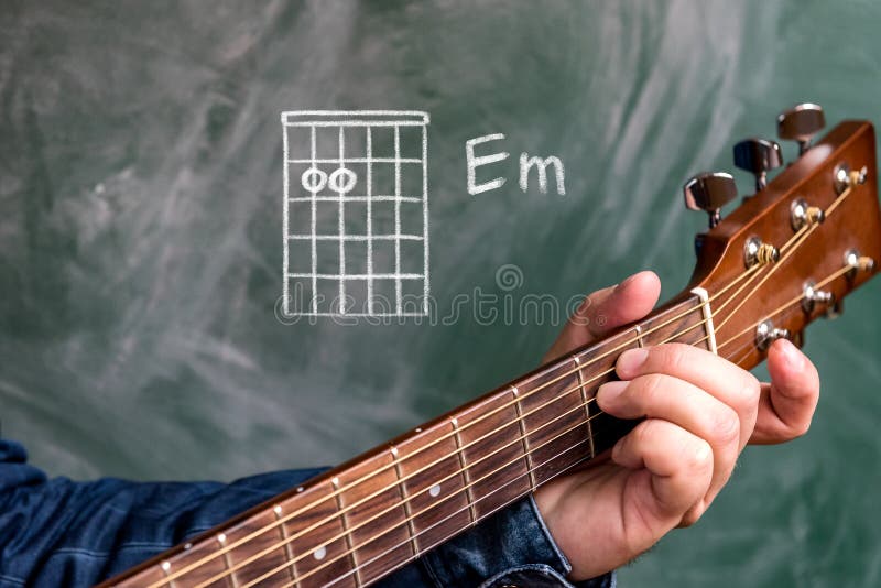 Sirva jugar los acordes de la guitarra exhibidos en una pizarra, menor del acorde E