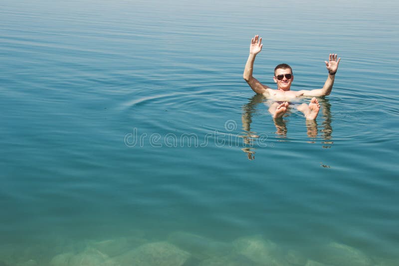 Sirva la mentira en el mar muerto del agua que disfruta de vacaciones en Jordania Reconstrucción del turismo, concepto sano de la foto de archivo libre de regalías Sirva la mentira en el mar muerto del agua que disfruta de vacaciones en Jordania Reconstrucción del turismo, concepto sano de la foto de archivo libre de regalías