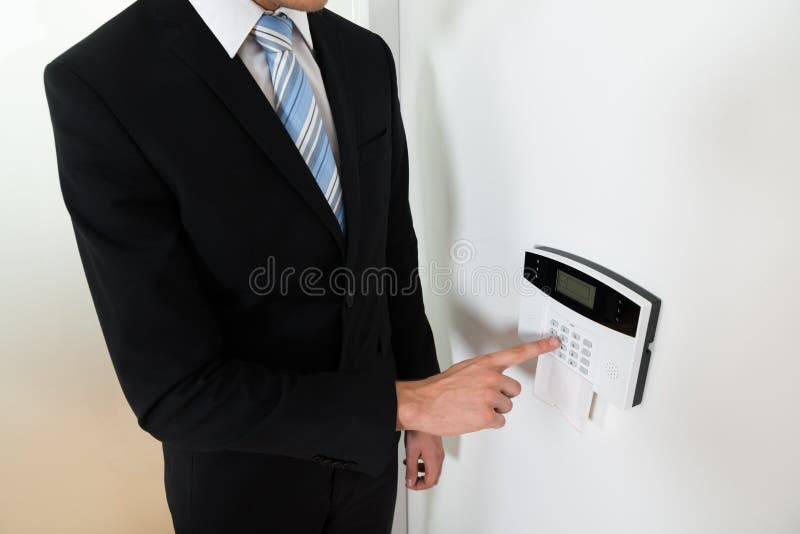 Sistema de alarma de Setting Home Security del hombre de negocios fotografía de archivo libre de regalías Sistema de alarma de Setting Home Security del hombre de negocios fotografía de archivo libre de regalías
