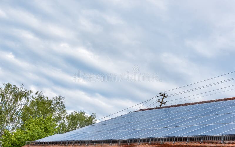 Sistema de los paneles solares instalado en el tejado debajo del cielo azul foto de archivo Sistema de los paneles solares instalado en el tejado debajo del cielo azul foto de archivo
