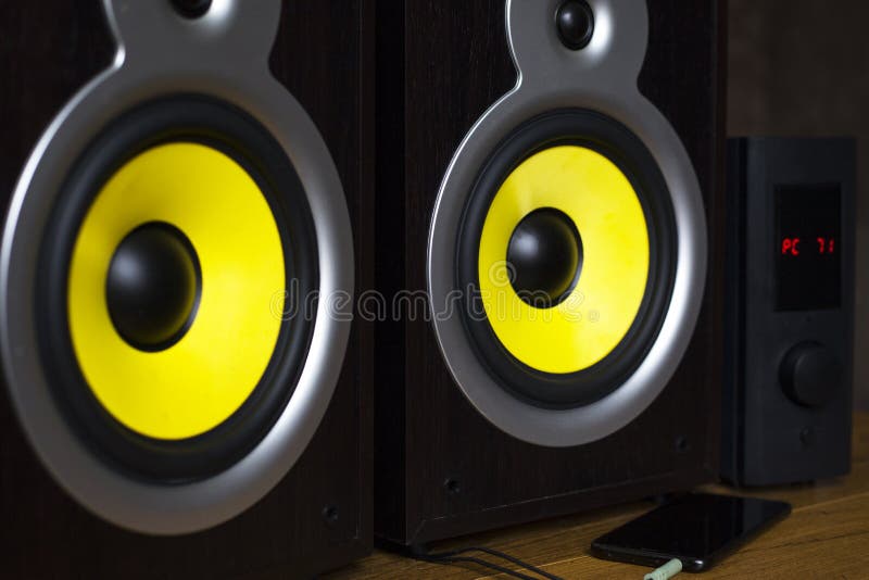Sistema de áudio que joga através dos oradores amarelos móveis, grandes conectados ao telefone imagem de stock royalty free Sistema de áudio que joga através dos oradores amarelos móveis, grandes conectados ao telefone imagem de stock royalty free