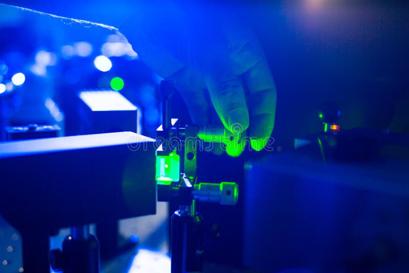 Sistema ótico do quantum - mão de um pesquisador que ajusta um raio laser