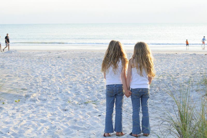 Sisters holding hands on the beach