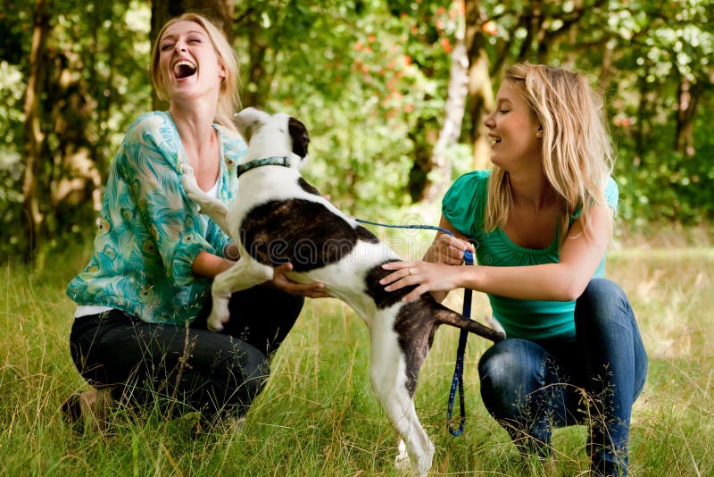 Sisters are playing with the dog