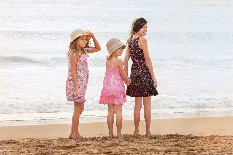 3 sisters stand on beachfront looking back at a person on the sh stock image 3 sisters stand on beachfront looking back at a person on the sh stock image