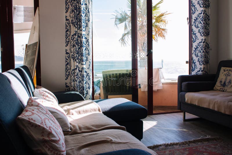 Sitio cómodo con el sofá y balcón con la opinión del mar Interior acogedor del apartamento Sala de estar con la decoración y mueb fotos de archivo libres de regalías Sitio cómodo con el sofá y balcón con la opinión del mar Interior acogedor del apartamento Sala de estar con la decoración y mueb fotos de archivo libres de regalías