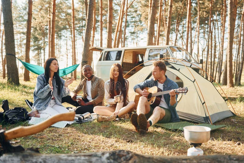 Sitt och vila. Ungdomsgruppen reser tillsammans i skogen på dagtid arkivbild