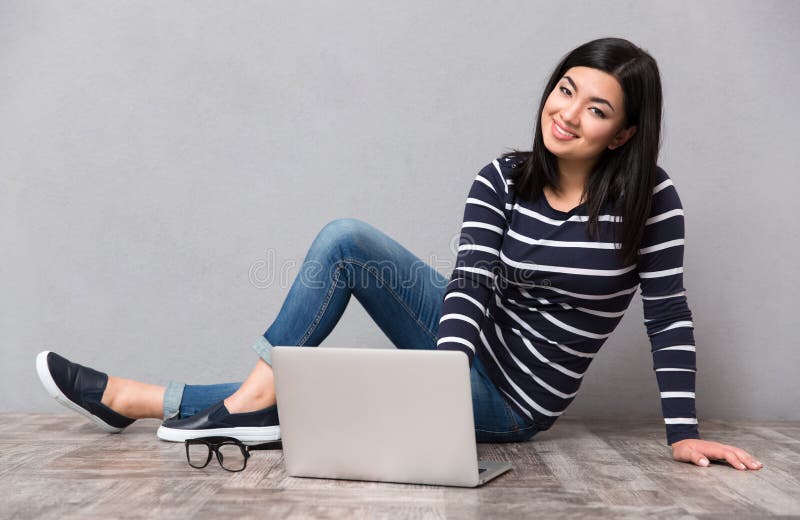 Sittande kvinna för golvbärbar dator royaltyfri fotografi