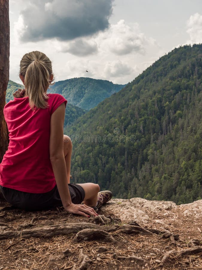 Woman sitting on a cliff stock image. Image of hill 148401747