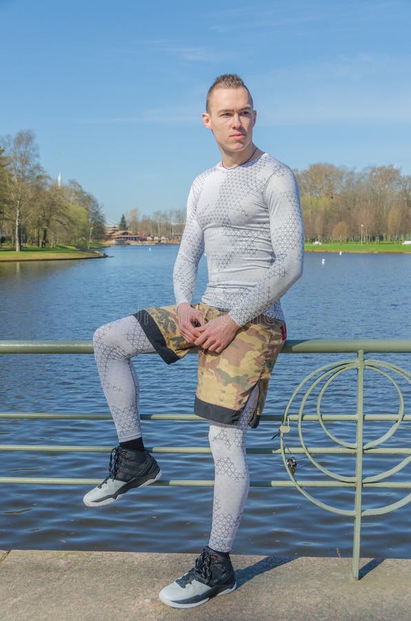 Sitting on a Railing by the River, Attractive Man in White Sport Stock ...