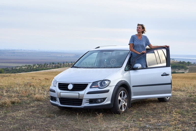 Situaci? n de la mujer que se inclina en una puerta de coche imagenes de archivo