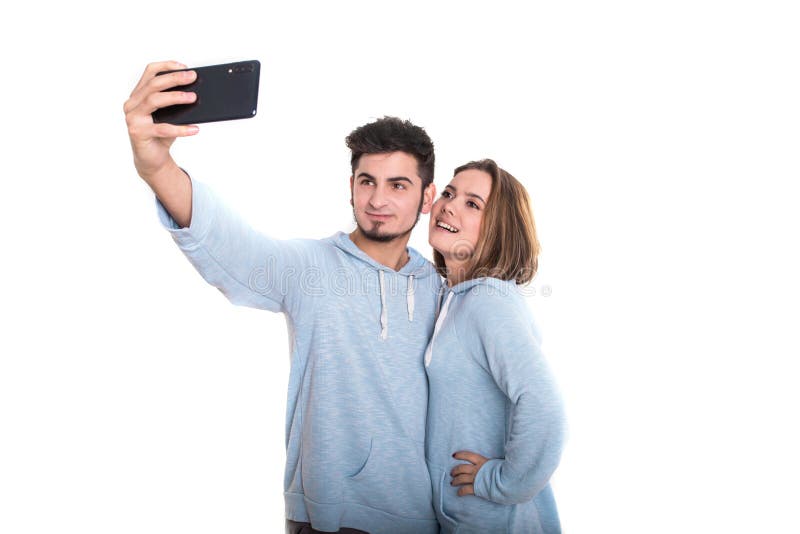 Situación de amor de los pares aislada en blanco y la fabricación del selfie usando el teléfono móvil fotografía de archivo libre de regalías Situación de amor de los pares aislada en blanco y la fabricación del selfie usando el teléfono móvil fotografía de archivo libre de regalías