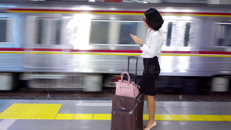Situación de la mujer de negocios en la plataforma de la estación almacen de metraje de vídeo
