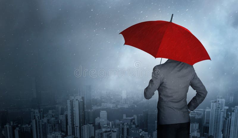 Situación del hombre de negocios mientras que sostiene un paraguas rojo sobre tormenta en fondo enorme de la lluvia