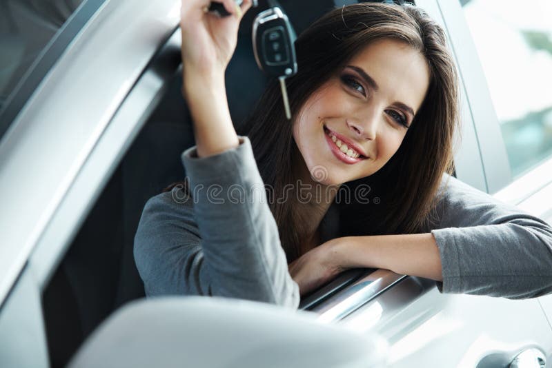 Situação de Holding Car Keys do motorista da mulher em seu carro novo foto de stock Situação de Holding Car Keys do motorista da mulher em seu carro novo foto de stock