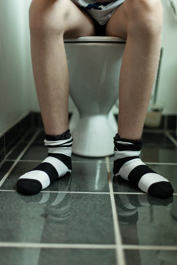 Sitzen auf einer Toilette lizenzfreie stockbilder Sitzen auf einer Toilette lizenzfreie stockbilder