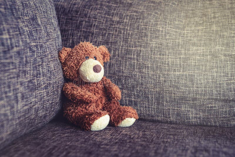 Sitzendes Sofa des alten Teddybären der Weinlese lizenzfreie stockbilder Sitzendes Sofa des alten Teddybären der Weinlese lizenzfreie stockbilder