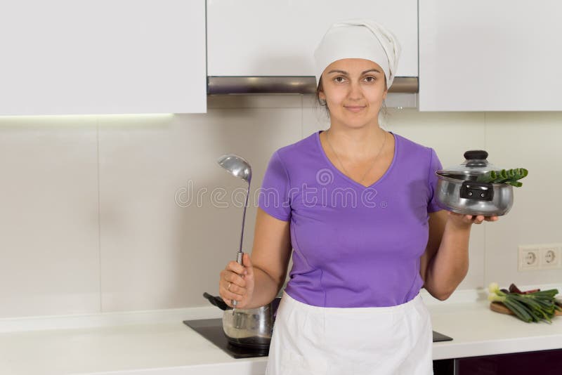 Siviera e vaso della tenuta della donna nella cucina fotografia stock libera da diritti Siviera e vaso della tenuta della donna nella cucina fotografia stock libera da diritti