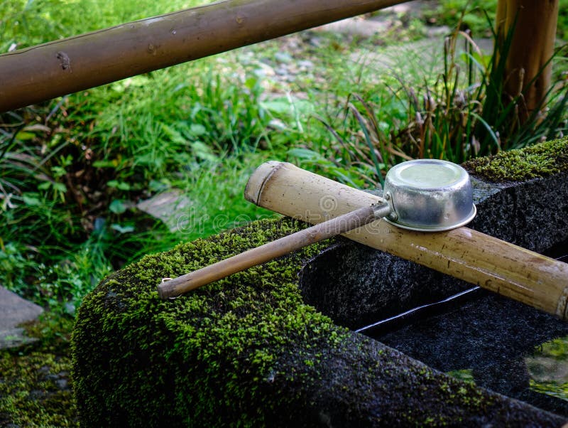 A Japanese ladle at Shinto temple in Akita, Japan. In Japan, a tsukubai is a washbasin provided at the entrance to holy places for visitors to purify themselves. A Japanese ladle at Shinto temple in Akita, Japan. In Japan, a tsukubai is a washbasin provided at the entrance to holy places for visitors to purify themselves.