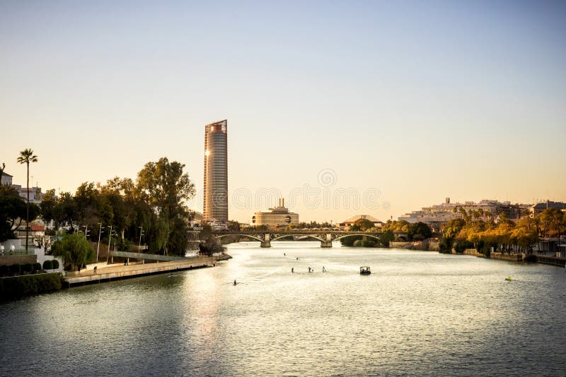 Siville - Mening van Siville-Toren Torre Sevilla van Sevilla, Andalusia, Spanje over rivier Guadalquivir bij zonsondergang stock afbeelding Siville - Mening van Siville-Toren Torre Sevilla van Sevilla, Andalusia, Spanje over rivier Guadalquivir bij zonsondergang stock afbeelding