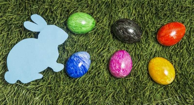 Six Colourful Eggs and Card Bunny Lay on Green Grass. Stock Image ...