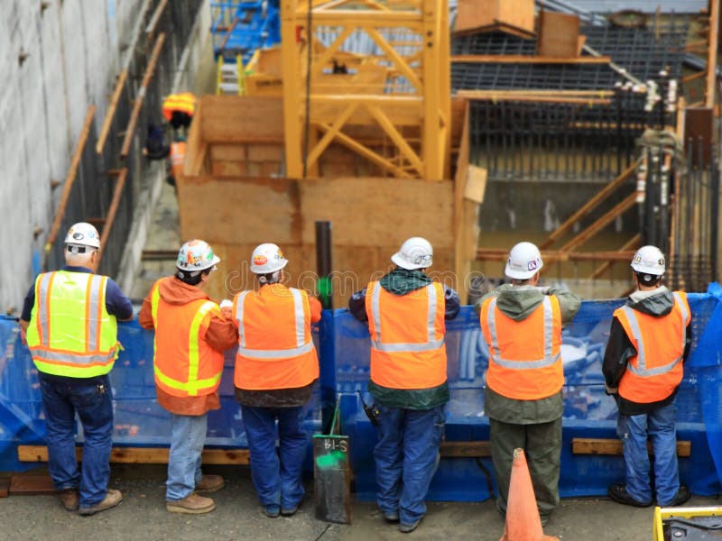 Six construction workers overlooking construction site