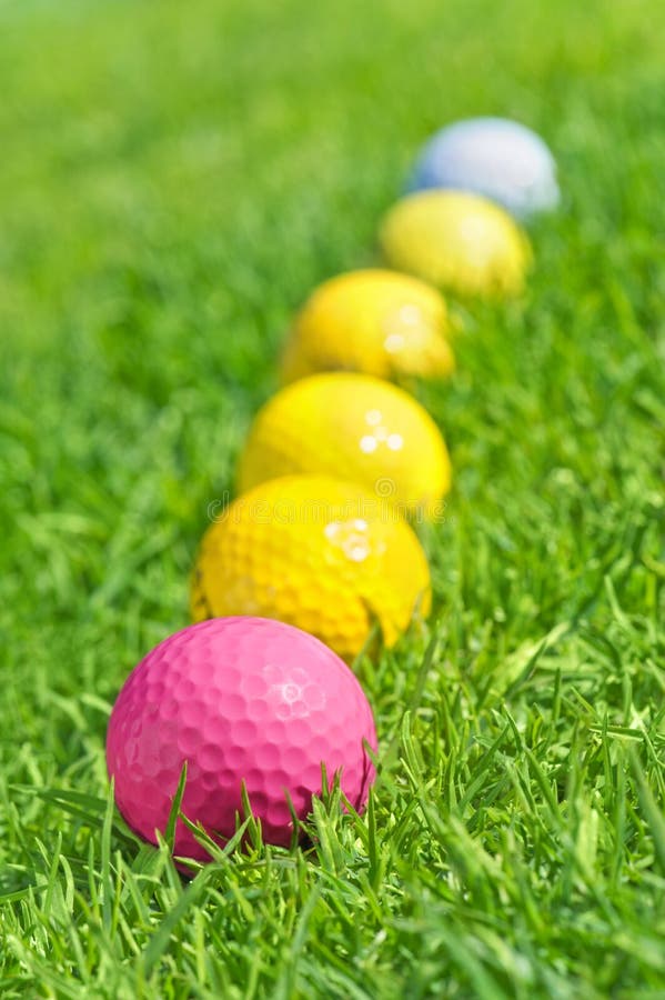 Six golf balls on the green grass